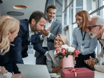 Colleagues celebrating with fresh flowers in a corporate office